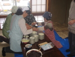 ならやま集落のお母さんたちは台所で餅を食べやすい大きさにとりわけ丸めています。